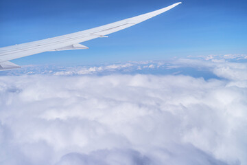 beautiful view from the airplane window flying above the clouds blue sky