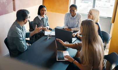 Team meeting with diverse professionals discussing ideas in a modern workspace