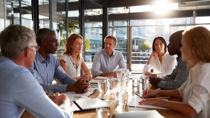 Boardroom Gathering: A diverse group of professionals engages in a productive and focused meeting within a modern office setting, fostering an atmosphere of collaboration and decision-making. - Powered by Adobe
