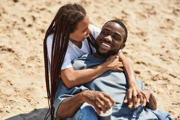 Young couple enjoys a romantic walk along the beach at sunset, sharing laughter and love
