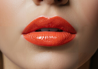Close-up of woman's lips with bright orange lipstick