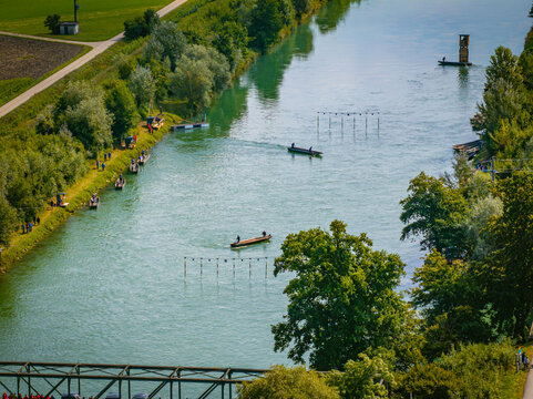 Aerial view of kayakers navigating the course on the river, amidst verdant trees and emerald waters, Augsburg, Bavaria, Germany.
