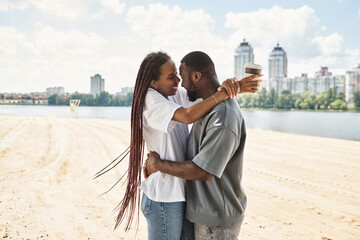 Young couple enjoys a romantic stroll along the riverside with smiles and warmth