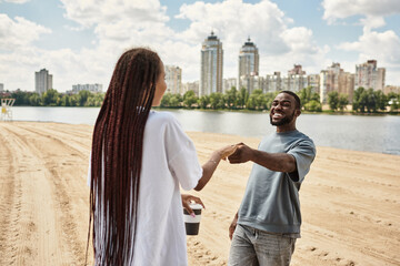 Young couple enjoys a romantic stroll by the river under a beautiful sky