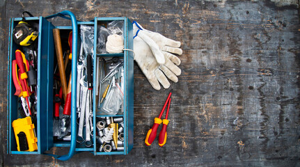 An open tool box photographed from above with many different tools in it.