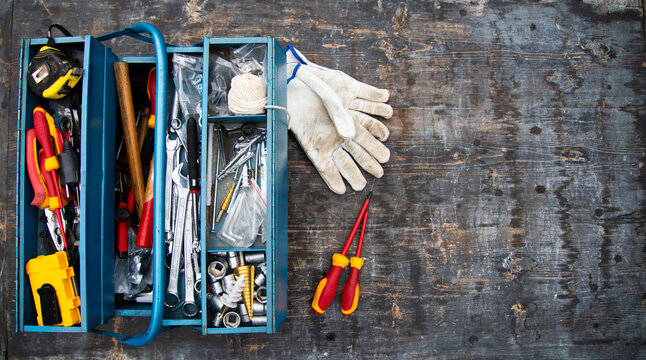 An open tool box photographed from above with many different tools in it.