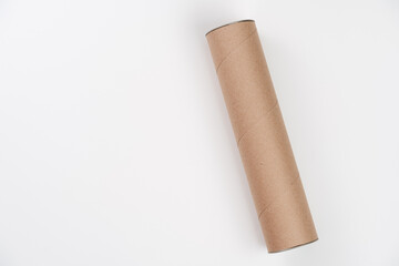Long cardboard tube lying on white background