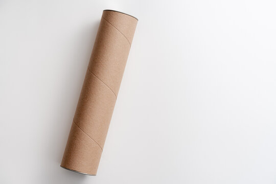 Long cardboard tube lying on white background - Powered by Adobe