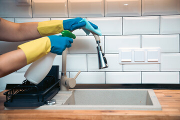 Using cleaning products for cleaning table in kitchen at home. Housekeeping, household chores.