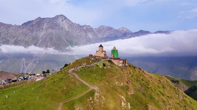 Mountain top landmark orthodox Christian chapel with scenic alpine peaks, caucuses, Georgia.