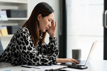 Tired asian businesswoman with headache at office, feeling sick at work.