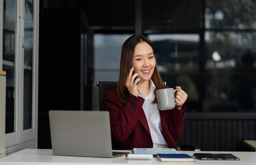 Business woman asian talking phones update plan working on laptop computers, online business.