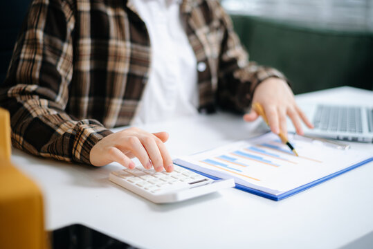 Businesswoman hands working with finances about cost and calculator and laptop with tablet, smartphone at office