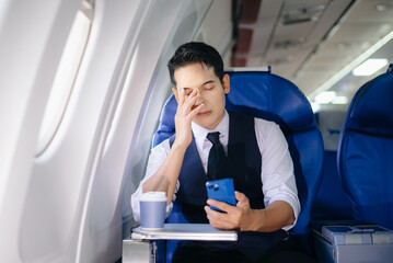 Tired businessman feeling stressed in first class during a work trip. Captures the concept of...