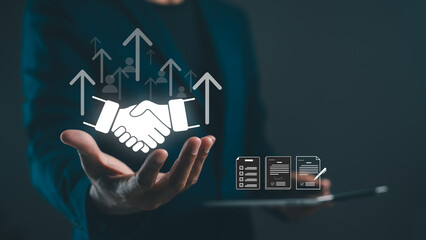 A business professional extends a hand for a handshake, symbolizing partnership and growth, with...