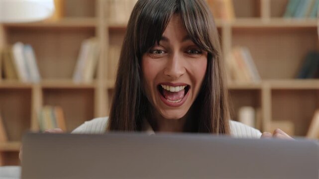 Excited gorgeous Caucasian woman opening mouth in joyful reaction. Reading amazing news online or discovering thrilling update while feeling rush of happiness and disbelief during work break.