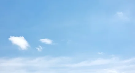 A serene and tranquil pale blue sky with a few wispy, soft white clouds. The minimalist composition and gentle colors create a peaceful backdrop, ideal for concepts of calm, relaxation, and purity. © โยธิน ทุมจีน