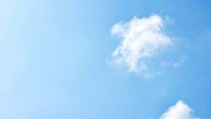 A bright, clear blue sky with a large, solitary white cloud in the upper right. The spacious, empty area on the left t makes it an ideal peaceful and minimalist backdrop for text or graphic overlays.