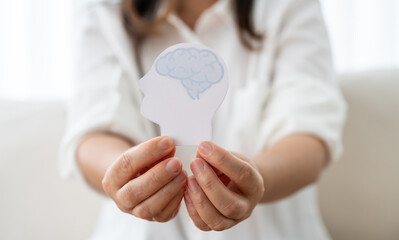 Mental health awareness, human hand care and support hold white paper head and glowing brain with physical and mental health, wellbeing, brain health, psychological support, healthcare and mindfulness