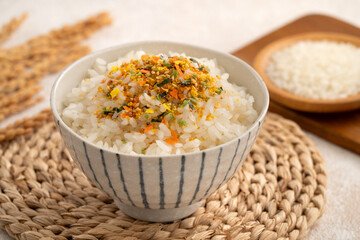 A bowl of white rice topped with sprinkle rice seasonings.