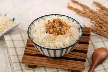 A bowl of white rice topped with sprinkle rice seasonings.