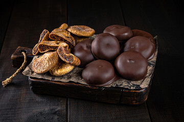 Fig in chocolate glaze on craft paper and wooden boards. Healthy sweets, natural desserts, sugar free treats, clean eating concept.