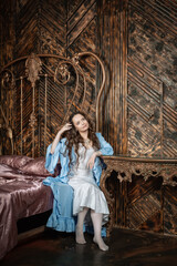 Beautiful sensual woman wears vintage underwear sitting in the medieval bedroom of the old castle...