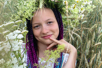 A twelve year old girl with multi-colored hair in a wreath of wild flowers