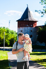 Fototapeta premium Zaraysk, Russia, 06.07.2024. A man is holding a young girl in a yellow dress