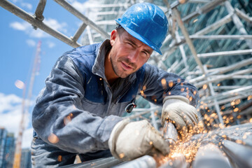 Worker performs metal welding at construction site under blue sky during daytime
