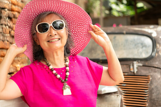 A happy senior woman strolling along a city's old neighborhood, enjoying travel