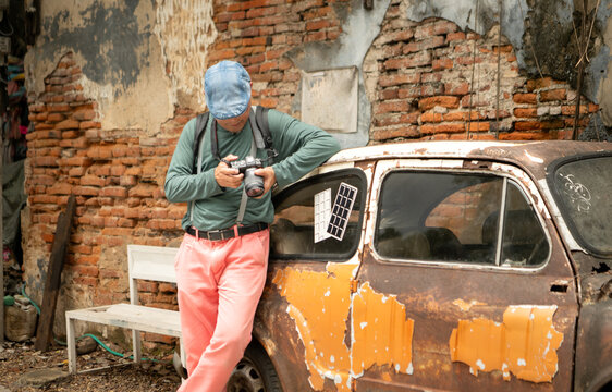A happy senior man strolling along a city's old neighborhood, enjoying travel