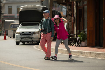 A happy senior couple strolling along a city's old neighborhood, enjoying travel