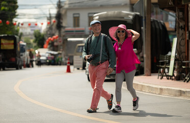A happy senior couple strolling along a city's old neighborhood, enjoying travel