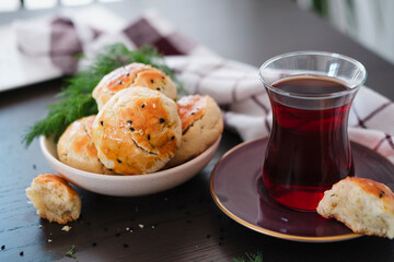 homemade turkish savory pastry pogaca with dill and black sesame or cumin, served with tea for breakfast or noon break