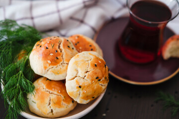 homemade turkish savory pastry pogaca with dill and black sesame or cumin, served with tea for breakfast or noon break