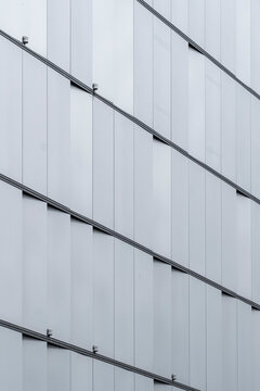 Minimalist white facade with vertical panels, architectural detail illustrating simplicity, clean design and abstract rhythm, adaptable for contemporary architectural backgrounds