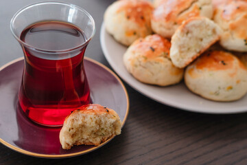homemade turkish savory pastry pogaca with dill and black sesame or cumin, served with tea for breakfast or noon break