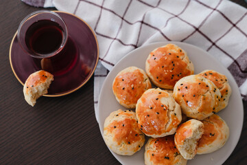 homemade turkish savory pastry pogaca with dill and black sesame or cumin, served with tea for breakfast or noon break