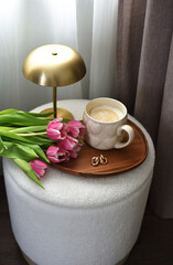 Cup with cappuccino, spring flowers tulips, morning concept, woman's day, bedroom design, gold modern desk lamp