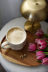 Cup with cappuccino, spring flowers tulips, morning concept, woman's day, bedroom design, gold modern desk lamp