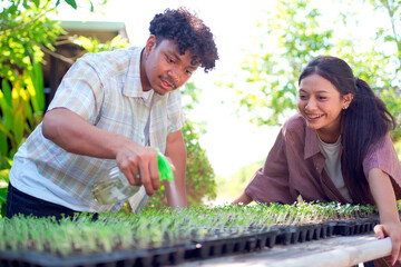 Male and female students checking vegetable growth and taking notes, symbolizing education and learning.