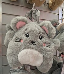 Mochila con forma de ratón sonriente en estante de comercio	
