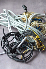 Hand holding a bundle of tangled electrical wires of different colors and thicknesses. Perfect for...