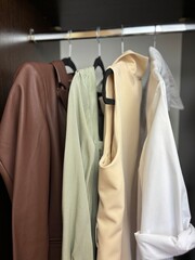 Obraz premium Business and casual clothes hanging on hangers in closet, women's wardrobe organization, women's fashion and clothing care