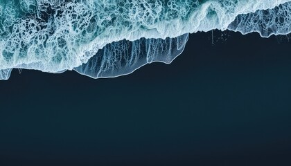 Waves crash onto the dark shore in an abstract aerial view, nature's power on display with turbulent waters