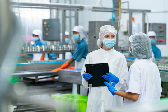 Canned processed food business entrepreneur manufacturing factory industry. Quality control officer inspecting raw material in production line. Worker preparing sardines packaging into aluminum cans. - Powered by Adobe