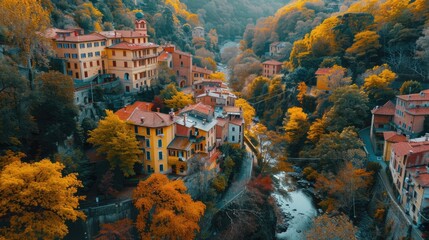 Aerial view of a circular urban park during autumn. The vibrant colorful trees in shades of orange, red, and yellow create a striking abstract pattern.