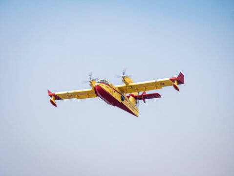 Ponferrada, Leon, Spain; 08-20-2025: A Spanish Canadair CL-215T seaplane resumes flight after collecting water from the Barcena reservoir and heads toward one of the devastating fires in El Bierzo