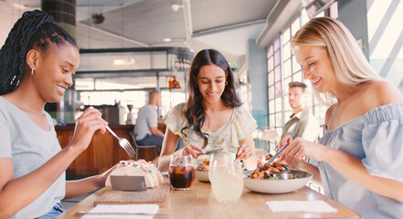 Group Of Female Friends Meeting Up In Restaurant Enjoying Meal Together